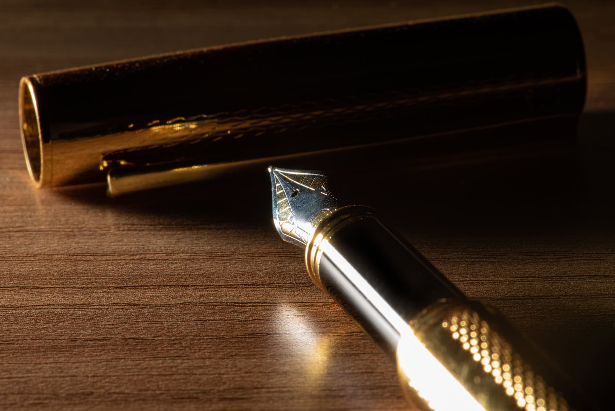 Luxury fountain pen on a wooden desk for an article about the best pens for every budget.