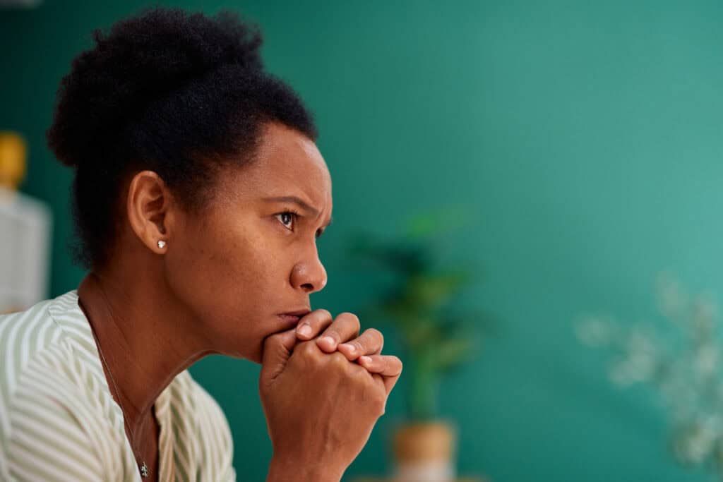 Midlife woman sitting quietly at home while experiencing caregiver burnout
