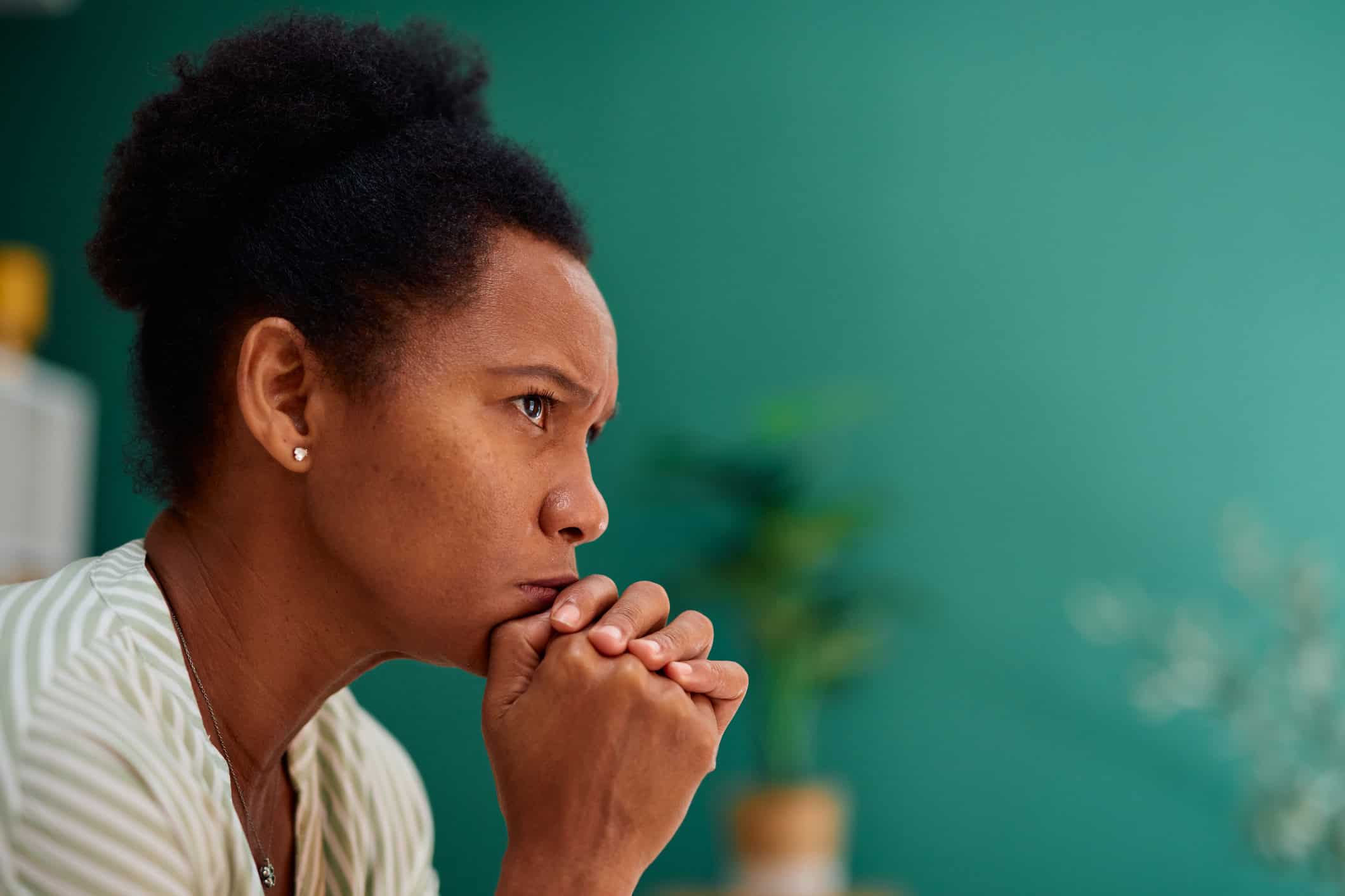 Midlife woman sitting quietly at home while experiencing caregiver burnout